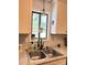 Farmhouse kitchen sink with white cabinets, grey countertops and natural light from window above at 6212 Sunset Cir, Charlotte, NC 28216