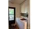 Bright laundry room with white cabinets and includes washer and dryer, and has access to the deck at 6212 Sunset Cir, Charlotte, NC 28216