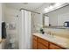 This bathroom features a shower with a curtain and a vanity with light wood cabinets and a modern faucet at 6307 Old Corral St, Charlotte, NC 28277