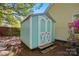 A quaint, turquoise shed with white trim and double doors stands ready for storage in the backyard at 6307 Old Corral St, Charlotte, NC 28277
