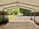 View of the carport and driveway of a residential property surrounded by a variety of green foliage at 6401 Alley Rd, Catawba, NC 28609