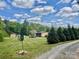Lush yard featuring mature evergreen trees and gravel driveway at 6401 Alley Rd, Catawba, NC 28609