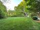 Spacious backyard with lush greenery, mature trees, and a well-kept lawn, perfect for outdoor activities and relaxation at 6726 Park Meadows Pl, Huntersville, NC 28078