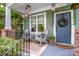 Cozy front porch with seating, decorative lanterns, and a welcoming wreath on the blue front door at 6726 Park Meadows Pl, Huntersville, NC 28078
