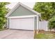 Detached two-car garage with white door and siding, providing secure parking and storage space at 6726 Park Meadows Pl, Huntersville, NC 28078
