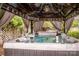 Hot tub with elegant gazebo featuring ambient lighting, curtains, and lush greenery surroundings at 6726 Park Meadows Pl, Huntersville, NC 28078