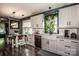 Spacious kitchen with a farmhouse sink, modern appliances, white cabinets, and an adjacent dining area at 6726 Park Meadows Pl, Huntersville, NC 28078