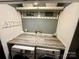 Efficient laundry room with modern washer and dryer, folding counter, and organized storage shelves above at 6726 Park Meadows Pl, Huntersville, NC 28078