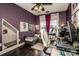 Cozy office with a purple accent wall, corner sofa, and a built-in dog house for a comfortable work environment at 6726 Park Meadows Pl, Huntersville, NC 28078