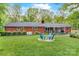 Backyard featuring mature shade trees, green grass, and Adirondack chairs around a firepit at 722 12Th Nw Ave, Hickory, NC 28601