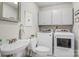 Laundry room with modern, matching washer and dryer units and an updated sink and fixtures at 722 12Th Nw Ave, Hickory, NC 28601