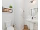 This bathroom features a pedestal sink, round mirror, and stylish storage shelves at 8011 Green Heron Ct, Belmont, NC 28012