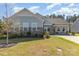 Charming single-Gathering home featuring stone accents, a well-manicured lawn, and inviting front porch with classic columns at 8011 Green Heron Ct, Belmont, NC 28012