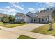 Charming single-story home featuring stone accents, a well-manicured lawn, and a two-car garage on a sunny day at 8011 Green Heron Ct, Belmont, NC 28012