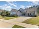 Charming single-story home with a two-car garage, stone accents, manicured lawn and covered front porch with rocking chairs at 8011 Green Heron Ct, Belmont, NC 28012