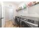 Laundry room with modern washer and dryer, wire rack shelving, and wood-look vinyl flooring at 8011 Green Heron Ct, Belmont, NC 28012