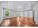 Primary bedroom boasts hardwood floors, a modern light fixture, and multiple windows at 8169 Clems Branch Rd, Indian Land, SC 29707