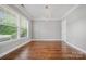 Bright living room with hardwood floors, large window, and modern light fixture at 8169 Clems Branch Rd, Indian Land, SC 29707
