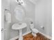 Charming powder room featuring a pedestal sink, updated fixtures, and wood floors at 8169 Clems Branch Rd, Indian Land, SC 29707