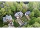Beautiful aerial view of a two-story home surrounded by mature trees and a well-manicured lawn with yellow flower beds at 9009 Tayside Ct, Huntersville, NC 28078