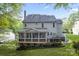 Exterior view featuring the back of the house, a large deck, screened porch, and manicured lawn at 9009 Tayside Ct, Huntersville, NC 28078