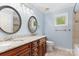 Stylish bathroom showcasing a double vanity, granite countertop, framed mirrors, and light blue walls at 9009 Tayside Ct, Huntersville, NC 28078