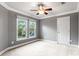 Cozy bedroom with a ceiling fan, soft carpet, and large windows framing neighborhood views at 9009 Tayside Ct, Huntersville, NC 28078