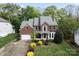 Beautiful two-story brick home with a well-manicured lawn, mature trees, and attached two car garage at 9009 Tayside Ct, Huntersville, NC 28078