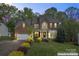 Charming two-story brick home with lush landscaping, manicured lawn, and a welcoming front entrance at 9009 Tayside Ct, Huntersville, NC 28078