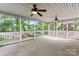 Screened porch providing serene views of lush greenery, complemented by dual ceiling fans at 9009 Tayside Ct, Huntersville, NC 28078