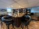 Finished basement bar with dark wood, bar stools, wine rack, and stainless steel fridge at 901 Ridge St, Albemarle, NC 28001