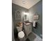 Cozy bathroom featuring gray walls, decorative bunnies, patterned floors, and a single vanity at 901 Ridge St, Albemarle, NC 28001