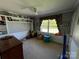 Bedroom with built-in shelving, neutral carpet, window with curtains, and play area at 901 Ridge St, Albemarle, NC 28001