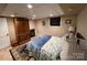 Bedroom features neutral walls, dark wood armoire and furniture, tiled flooring, and patterned bedding at 901 Ridge St, Albemarle, NC 28001