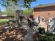 An inviting outdoor patio with a stone fireplace, grill, dining set, and beautifully landscaped backyard at 901 Ridge St, Albemarle, NC 28001