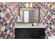 Chic powder room with vibrant floral wallpaper, black vanity with marble countertop, and a gold faucet at 9020 Tynecastle Commons Ct, Charlotte, NC 28226