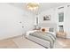 Bright bedroom featuring hardwood floors, natural light, modern chandelier, white linens, and decorative pillows at 9020 Tynecastle Commons Ct, Charlotte, NC 28226