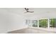 Spacious bedroom with hardwood floors, white walls, a modern ceiling fan, and large windows at 9020 Tynecastle Commons Ct, Charlotte, NC 28226