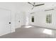 Bright bedroom with gray carpet, white walls, ceiling fan and two windows with dark frames at 9020 Tynecastle Commons Ct, Charlotte, NC 28226