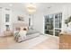 Bright bedroom with hardwood floors, natural light, modern chandelier, white linens, and decorative pillows at 9020 Tynecastle Commons Ct, Charlotte, NC 28226