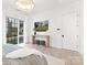 Bedroom with hardwood floors, natural light, modern chandelier, a table with stools, and white linens at 9020 Tynecastle Commons Ct, Charlotte, NC 28226