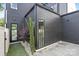 Dark wood paneled exterior of modern home with dark framed windows and door, and stone patio and small garden at 9020 Tynecastle Commons Ct, Charlotte, NC 28226