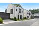 Charming modern-style townhome with black frame windows, light brick, manicured landscaping, and a black two-car garage at 9020 Tynecastle Commons Ct, Charlotte, NC 28226