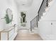 Bright foyer features hardwood floors, modern staircase with metal railings, and stylish console table and decor at 9020 Tynecastle Commons Ct, Charlotte, NC 28226
