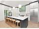 Modern kitchen boasts a large island with barstool seating, stainless appliances, and a custom vent hood at 9020 Tynecastle Commons Ct, Charlotte, NC 28226