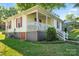 Charming home exterior with a covered front porch, green lawn, and lush landscaping at 912 W A St, Kannapolis, NC 28081