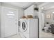 Bright laundry room with modern washer and dryer next to the side door and bathroom at 912 W A St, Kannapolis, NC 28081