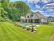 Well-manicured lawn leads to a stunning pool area with lounge chairs and lush landscaping at 100 Verbena Ct, Weddington, NC 28173