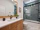 Well-lit bathroom with wood vanity and a glass-enclosed shower at 100 Verbena Ct, Weddington, NC 28173