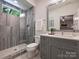 Bright bathroom with gray tiled shower and vanity with modern fixtures at 100 Verbena Ct, Weddington, NC 28173